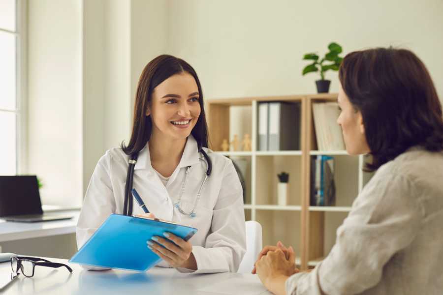 Médecin souriante consultant une patiente, illustrant l'accès aux soins de qualité que peut garantir une mutuelle indépendants adaptée