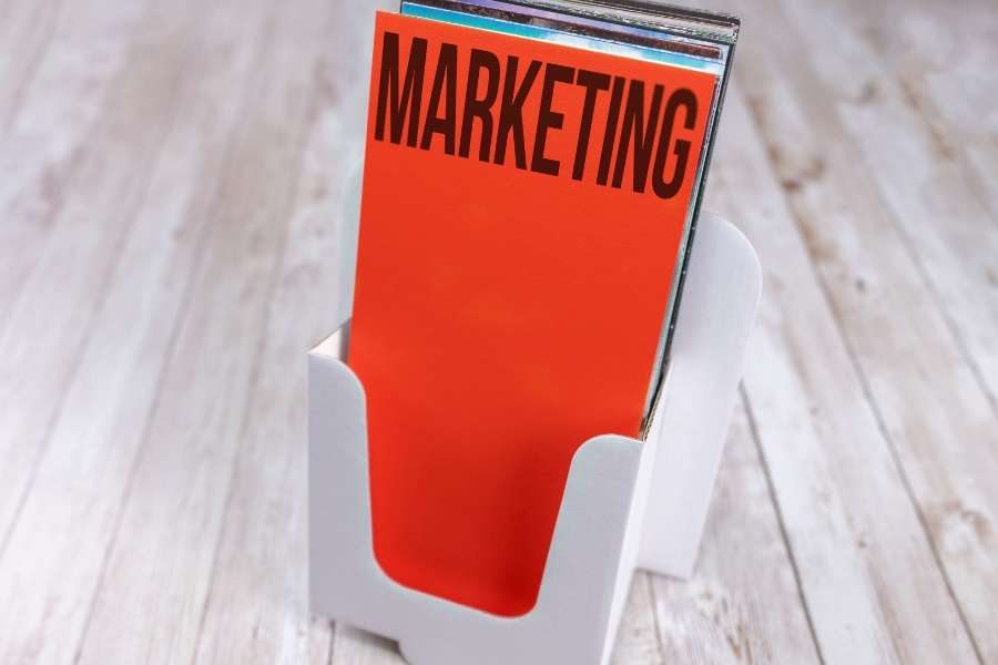 Un présentoir de table contenant un flyer pas cher de couleur rouge avec l'inscription marketing.